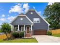 Charming home showcasing a well-manicured lawn, covered porch with columns, and attached garage at 516 King St, Waxhaw, NC 28173