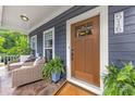 Inviting covered porch with comfortable seating, decorative plants, and a charming front door at 516 King St, Waxhaw, NC 28173
