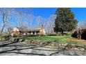 Beautifully landscaped front yard with lush green grass, mature trees, and a charming stone wall at 700 Valleyview Dr # 1, Albemarle, NC 28001