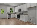Bright kitchen featuring stainless steel appliances, granite counters and white cabinets at 706 Live Oak St, Shelby, NC 28150