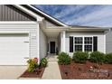 Attractive single-story home featuring a two-car garage, charming front porch, and well-maintained landscaping at 7315 Amberly Hills Rd, Charlotte, NC 28215