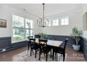 Bright dining room featuring classic wainscoting, a modern chandelier, and large windows at 8916 Inverness Bay Rd, Charlotte, NC 28278