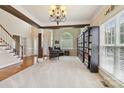 Bright living room featuring a staircase, large windows, and custom built-in bookshelves at 9034 Kensington Forest Dr, Harrisburg, NC 28075