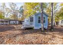 Light blue house with small porch and deck, nestled in a setting surrounded by trees at 108 Sailors Ct # 108 B, Mount Gilead, NC 27306