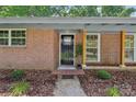 Close-up of the front entrance with a black door, brick facade, and well-kept landscaping at 1192 Carolyn Dr # 9, Albemarle, NC 28001