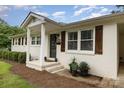 Close up of charming white brick home with wooden shutters and freshly landscaped front porch at 127 Leonidas St, Fort Mill, SC 29715