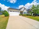 Single-story home with a well-maintained lawn, two-car garage, and charming curb appeal at 1456 Augustus Beamon Dr, Indian Trail, NC 28079