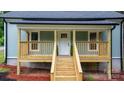 Inviting front porch features a white door, wooden railings, and freshly stained stairs at 18 S Coulter Ave, Newton, NC 28658