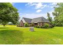Well-maintained brick home featuring mature trees and a spacious front yard, showcasing curb appeal at 1825 Smyre Farm Rd, Newton, NC 28658