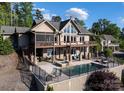 Lake house featuring a pool, patio with firepit, decks, and stone pillar supports, with an expansive rear exterior at 204 Ridge Dr # 12 12-1 12-2, Troy, NC 27371