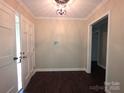 Inviting entryway featuring wood-look flooring, fresh paint, and updated lighting fixture at 3316 Mckee Rd, Charlotte, NC 28270