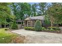 Quaint stone home featuring a pergola, lush landscaping, and a private fenced yard at 4235 Howie Cir, Charlotte, NC 28205