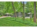 View of mid-century modern home exterior featuring gray facade and lush landscaping at 447 Merwick Cir, Charlotte, NC 28211