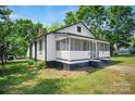 Quaint home with a screened-in porch, nestled among mature trees, in need of some tender loving care at 514 S Martin St, Shelby, NC 28150