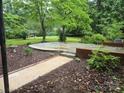 Backyard featuring a concrete patio surrounded by mulch beds, landscaping and trees at 520 Crestview Dr, Albemarle, NC 28001