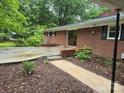 Exterior view of brick home featuring a patio and brick retaining wall at 520 Crestview Dr, Albemarle, NC 28001
