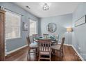 Cozy dining room featuring a stylish light fixture, hardwood floors, and a decorative wall mirror at 6119 Castlecove Rd, Charlotte, NC 28278