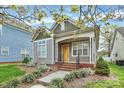 Quaint home showcasing a bright yellow front door, brick steps, and manicured landscaping at 6705 E Douglas Park Dr, Huntersville, NC 28078