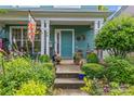 Inviting front porch with colorful decor, lush plants, and a welcoming entrance to the home at 6827 Dunton St, Huntersville, NC 28078