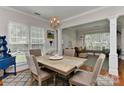 Open concept dining room with wood floors, a decorative chandelier, and a view into the living room at 705 Moss Creek Dr, Matthews, NC 28105