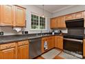 Functional kitchen with stainless steel appliances, wood cabinets, and a view of the backyard at 705 Moss Creek Dr, Matthews, NC 28105