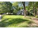 Suburban home with a sprawling front lawn and mature trees creating a park-like setting at 7226 Reedy Creek Rd, Charlotte, NC 28215