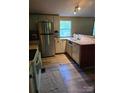 Open kitchen with stainless steel refrigerator, neutral cabinets, butcher block counters, and durable flooring at 850 Meadowbend Dr, York, SC 29745