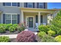 Cozy front porch with a welcoming entrance, a wreath, and decorative plants at 11101 Crane Creek Dr, Charlotte, NC 28278
