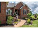 Beautiful brick home with landscaped walkway and lush garden beds on a sunny day at 1111 Lizzie Ln, Salisbury, NC 28147