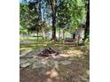 A cozy backyard fire pit surrounded by flagstone pavers, with a swing visible in the treed background at 11718 Battery Pl, Charlotte, NC 28273