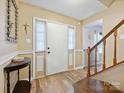 Warm and inviting foyer with wood floors, staircase, and a decorative accent table at 11718 Battery Pl, Charlotte, NC 28273
