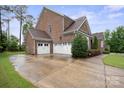 Spacious driveway leading to a multi-car garage with lush greenery around the property at 13102 Indigo Run Ct, Charlotte, NC 28278