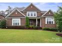 Charming brick home featuring a well-manicured lawn, and manicured landscaping at 13102 Indigo Run Ct, Charlotte, NC 28278