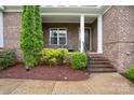 Inviting front porch with brick columns and detailed trim, enhancing curb appeal at 13102 Indigo Run Ct, Charlotte, NC 28278