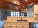 Kitchen boasts stainless appliances, white cabinetry, and stylish tile backsplash, with wood ceiling detail at 1351 Hardin Rd, Dallas, NC 28034