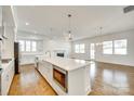 Open concept kitchen with stainless steel appliances, an island with a microwave, and wood floors at 13702 Tranquil Day Dr, Matthews, NC 28105