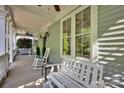 Cozy covered porch featuring rocking chairs, a bench, and ceiling fans for outdoor comfort at 15430 Waterfront Dr, Huntersville, NC 28078