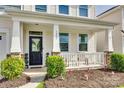 Inviting front porch with decorative columns, manicured shrubs and a beautifully landscaped garden bed at 1553 Arcadia Bluff Dr, York, SC 29745