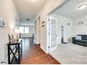 Hallway with hardwood floors leading to a carpeted room with white trim and a view of the staircase at 1553 Arcadia Bluff Dr, York, SC 29745