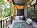 Charming front porch with comfortable seating, a patterned rug, and views of the surrounding woods at 167 Greenbay Rd, Mooresville, NC 28117