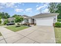 Single-story home with a two-car garage, and well-maintained lawn on a sunny day at 1813 Shelbourne Way, Fort Mill, SC 29707