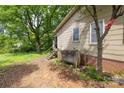 View of backyard with lush greenery, mature trees, and home's exterior at 208 N School St, Mount Gilead, NC 27306
