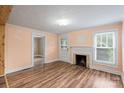 Living room with wood-look floors, fireplace, and entry door at 24515 Saint Martin Rd, Albemarle, NC 28001