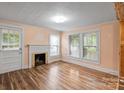 Inviting living room featuring a fireplace, hardwood floors, and natural light from the windows at 24515 Saint Martin Rd, Albemarle, NC 28001