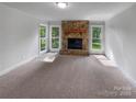 Bright, spacious living room featuring a stone fireplace and large windows offering ample natural light at 2532 Steeplechase Rd, Gastonia, NC 28056