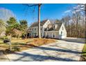 Well-maintained two-story home featuring an attached garage and spacious driveway, surrounded by mature trees at 2702 Oxborough Dr, Matthews, NC 28105