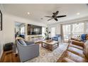 Comfortable living room featuring hardwood floors, ceiling fan and plenty of natural light from the windows at 2702 Oxborough Dr, Matthews, NC 28105