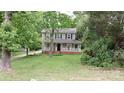 Charming two-story home with a welcoming front porch nestled among mature trees and lush greenery at 2716 Rea Rd, Charlotte, NC 28226