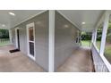 Inviting covered porch showcasing neutral siding, white trim, recessed lighting, and serene outdoor views at 2716 Rea Rd, Charlotte, NC 28226