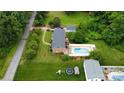 An aerial view shows the home, large pool, green space and neighboring properties in a wooded area at 2968 Grace St, Claremont, NC 28610